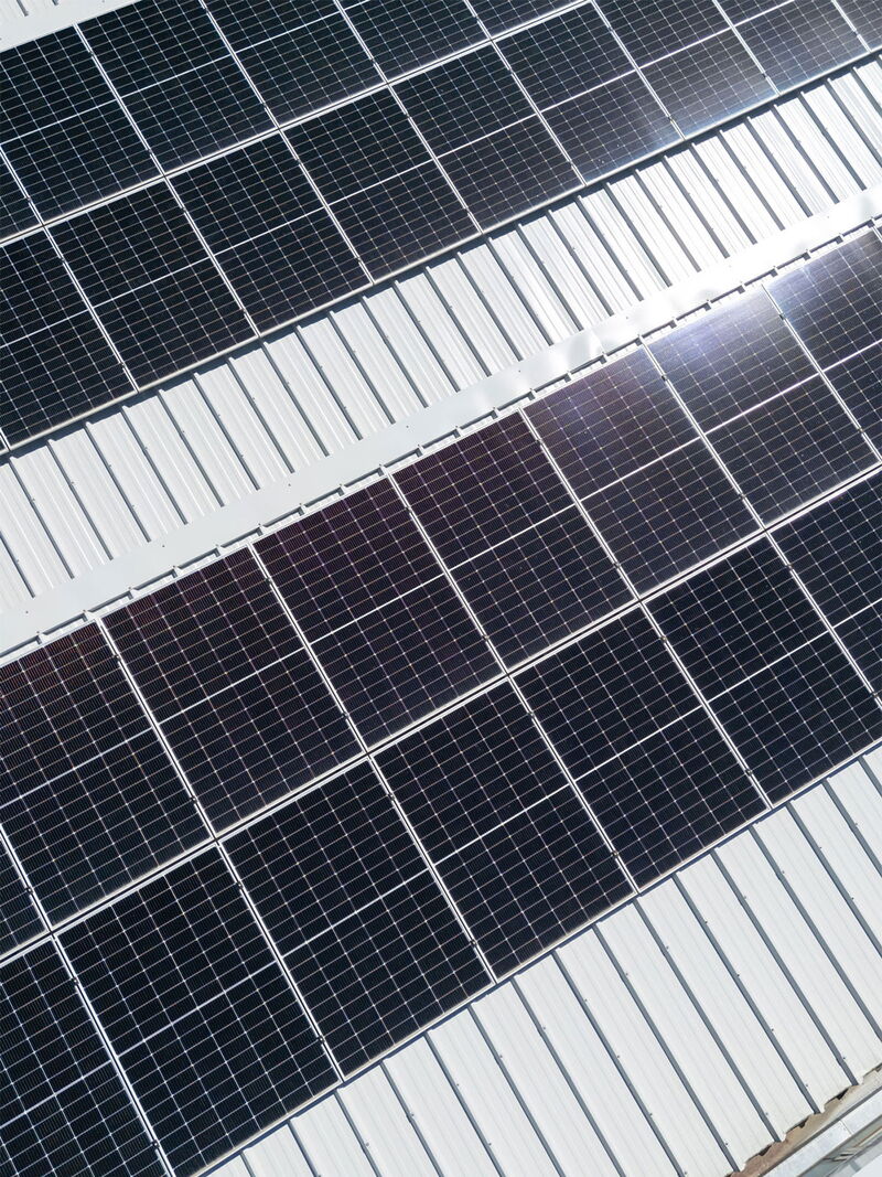 Nahaufnahme von glänzenden Solarpanels auf einem Schrägdach bei Tageslicht