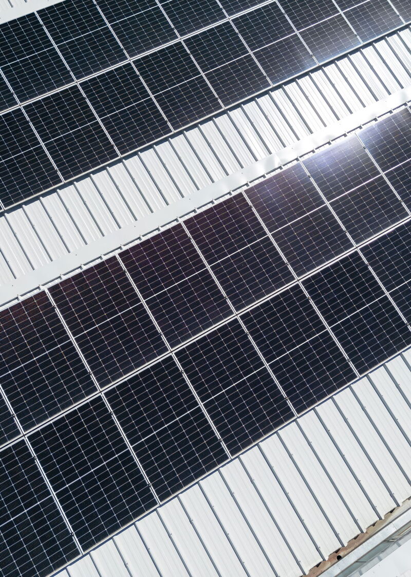 Nahaufnahme von glänzenden Solarpanels auf einem Schrägdach bei Tageslicht